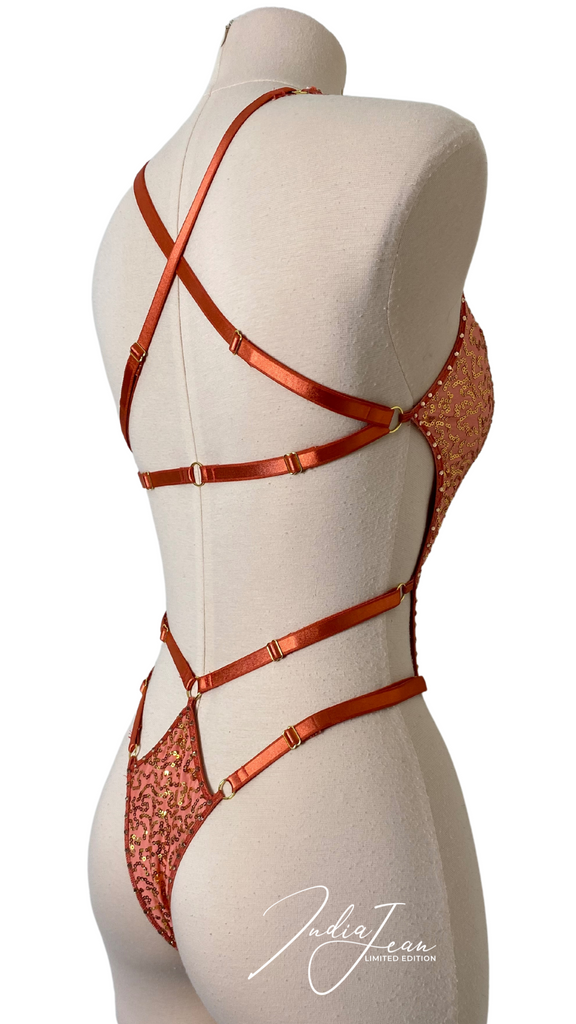 Side profile picture of golden coral leotard with adjustable back waist and hip straps